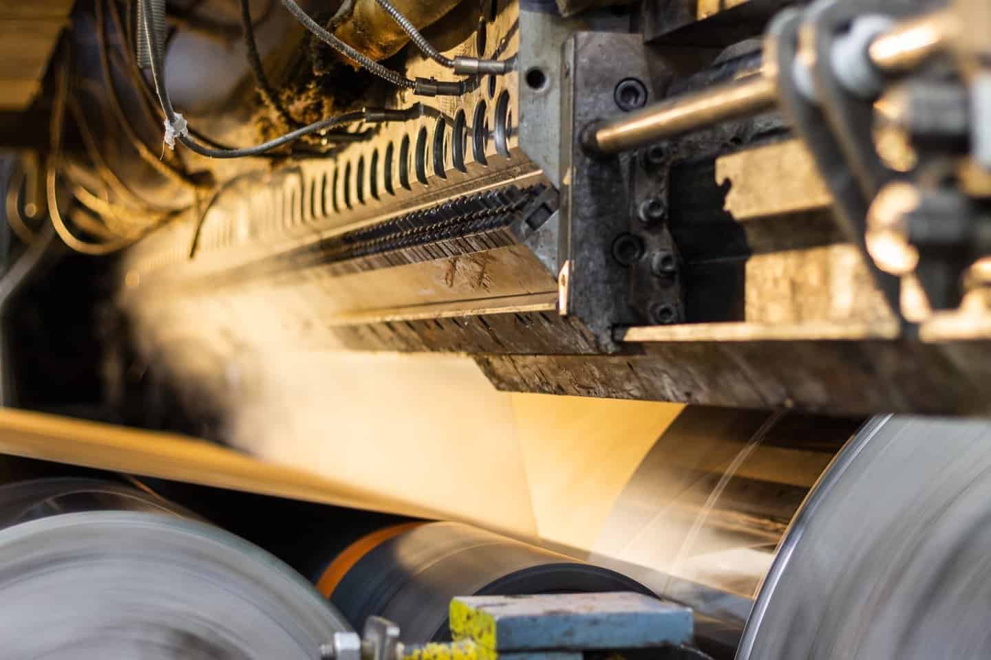 Molten polyethylene coating a kraft web as it passes between chill rolls on the extrusion line